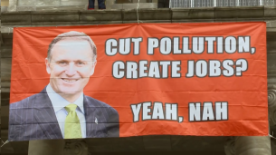 greenpeace banner outside parliament with John Key